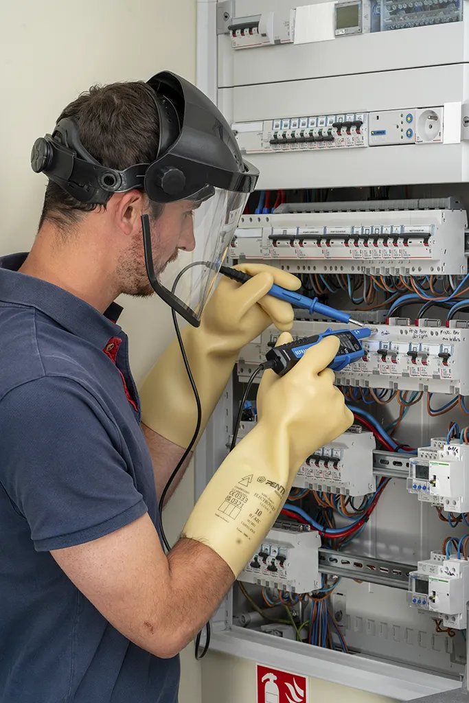 Formation habilitation basse tension recyclage — électricien testant une armoire basse tension I2S Prévention