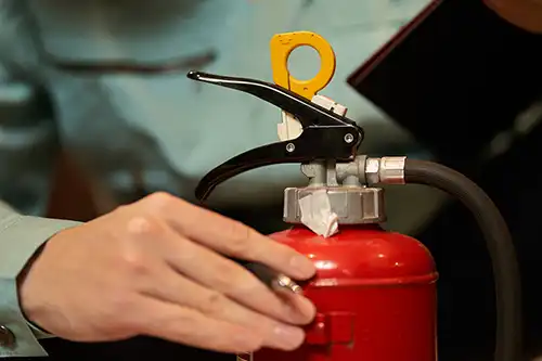 Formateur en sécurité incendie manipulant un extincteur lors d’une formation pratique en entreprise
