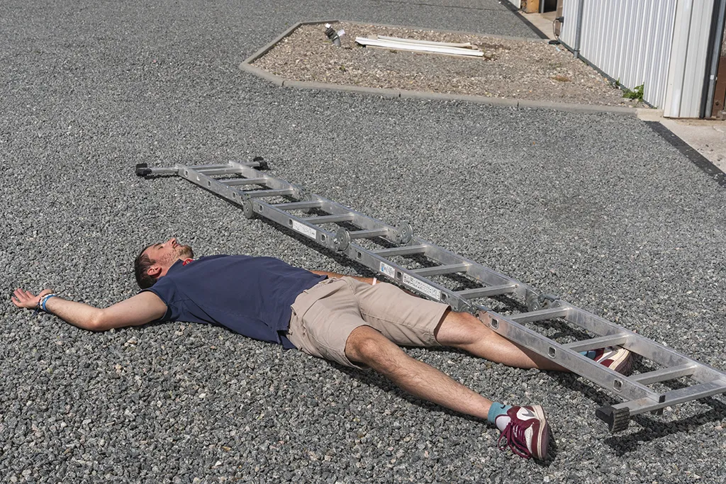 Formation SST – homme simulant une chute avec échelle