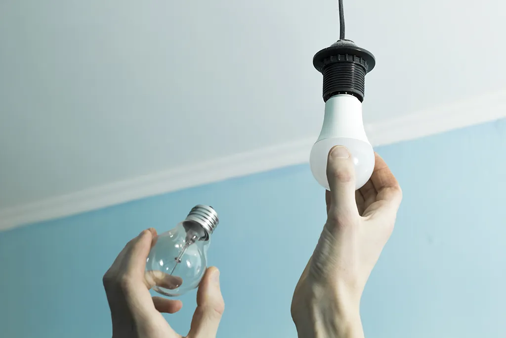 Personne remplaçant une ampoule électrique en toute sécurité