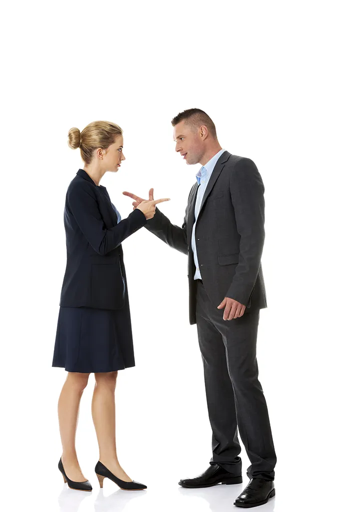 Un homme et une femme en costume discutent vivement, illustrant une dispute professionnelle